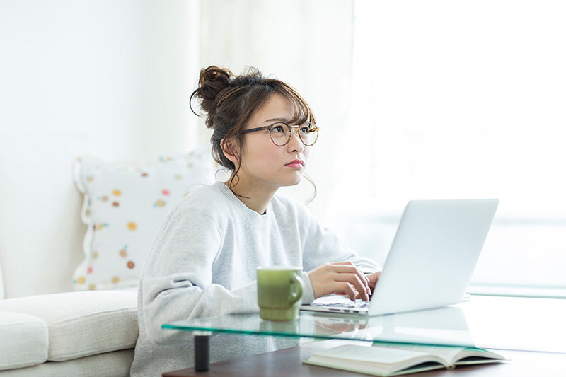 PCを前に悩む女性